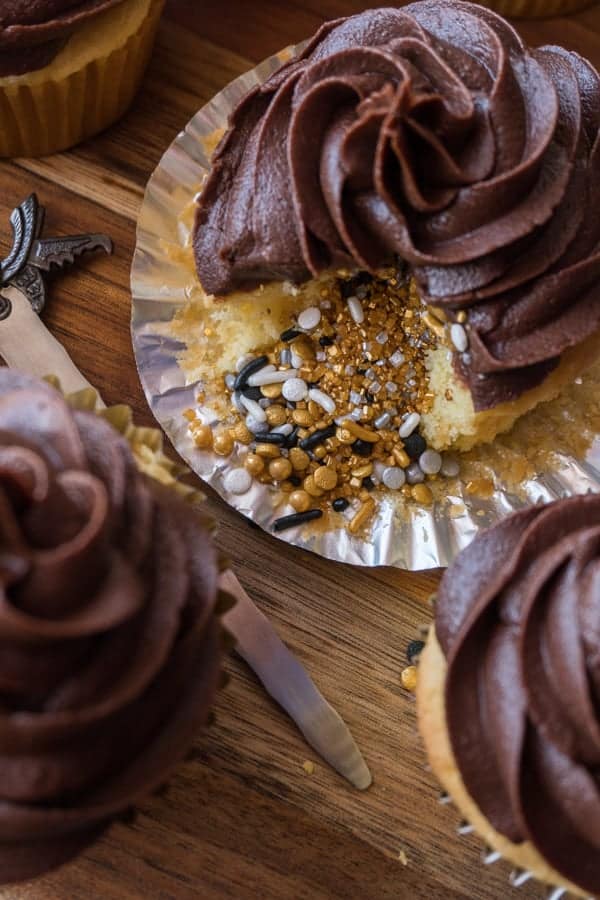 Yellow Cupcakes with sprinkles inside and chocolate frosting