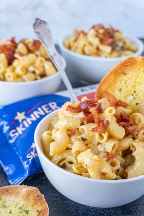 Mac and Cheese in bowl with pasta bag in background