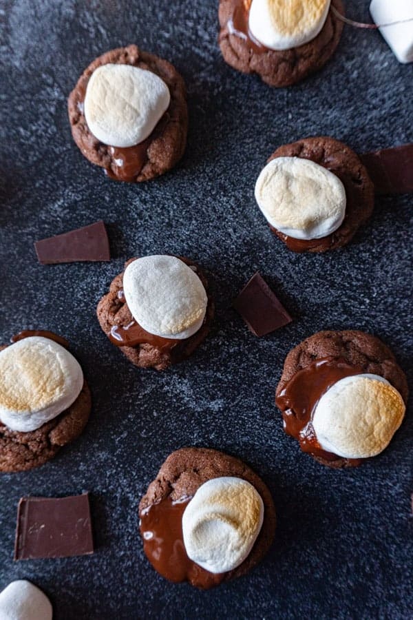 Top down of hot chocolate cookies with chocolate pieces around them 